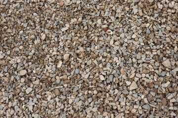 Abstract rock texture with light brown gray pebble stones as background pattern