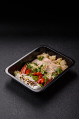 Bowl with caesar salad with chicken, parmesan cheese, tomatoes, croutons, lettuce leaves