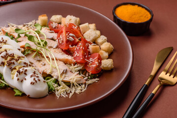 Bowl with caesar salad with chicken, parmesan cheese, tomatoes, croutons, lettuce leaves
