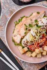 Bowl with caesar salad with chicken, parmesan cheese, tomatoes, croutons, lettuce leaves