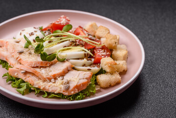 Bowl with caesar salad with chicken, parmesan cheese, tomatoes, croutons, lettuce leaves