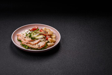 Bowl with caesar salad with chicken, parmesan cheese, tomatoes, croutons, lettuce leaves