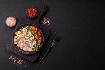 Bowl with caesar salad with chicken, parmesan cheese, tomatoes, croutons, lettuce leaves