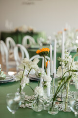 Wedding banquet hall decor with round green tables, white roses and sunflowers on the tables