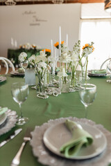 Wedding banquet hall decor with round green tables, white roses and sunflowers on the tables