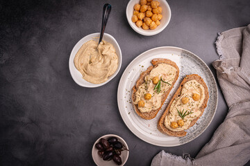 Delicious sandwiches with hummus and ingredients on a dark background, top view, flat lay. High quality photo