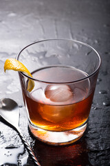 A Sazerac cocktail on a black table. Side view, close-up.