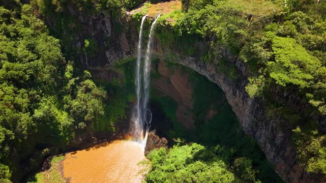 Aerial footage of Majestic Tropical Chamarel Waterfall Plunging into Canyon Pool.Spectacular Drone Shot of a High Waterfall in a Verdant Forest Landscape.