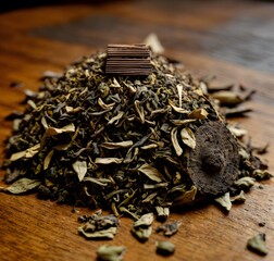 Macro shot of a small pile of tea leaves on a polished wooden surface, showcasing intricate details. Generative AI