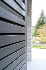 Obraz premium Modern architectural design featuring wooden slats, creating a stylish exterior at a residential property during daylight hours in a serene landscaped environment