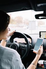 Unrecognizable female driver using gps navigator in car