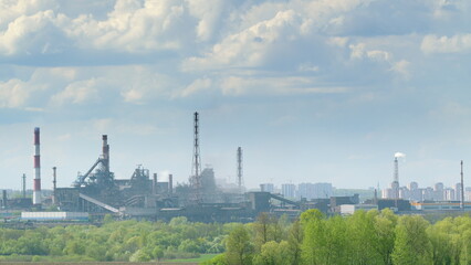 Fototapeta premium Industrial Landscape Featuring Prominent Smokestacks and a Dramatic Cloudy Sky Above