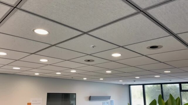 A medium closeup of an acoustic ceiling tile with integrated lighting designed to reduce sound while creating a calm environment for deliberation.
