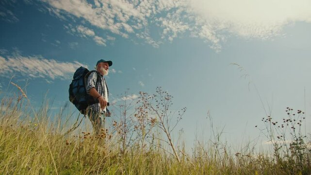 Cardiovascular Health, Mental Wellness, Active Aging. Senior Man Hikes in the Mountains, Enjoying Retirement and Nature. Inspiring Scene of Freedom, Strength, and Positive Aging