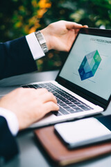 Unrecognizable businessman working with laptop in cafe