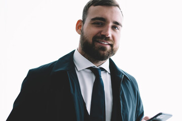 Positive businessman with smartphone looking at camera