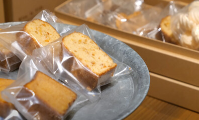 Individually wrapped slices of pound cake displayed on a tray, ready for packaging or sale in a bakery or dessert shop setting.
