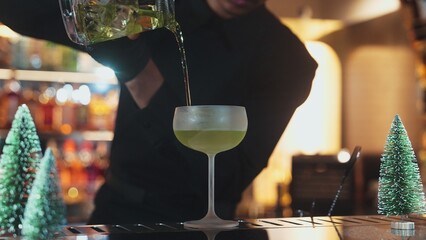 Bartender preparing to serve Midori sour with lime syrup pouring into saucer glass. Focusing special refresh japanese liqueur drink style showcasing nightlife mixology at nightclub luxury. Vinosity.