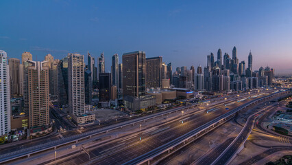 Dubai Marina skyscrapers aerial top view before sunrise from JLT in Dubai night to day timelapse, UAE.