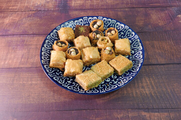 A blue plate with a variety of pastries on it. The plate is on a wooden table