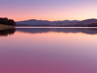 Fototapeta premium Serene lake reflection at twilight with pastel colors and distant mountains offering a tranquil nature scene for peaceful contemplation and scenic beauty