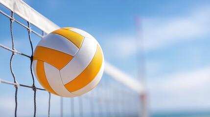 Yellow and white volleyball mid-air above net with blue sky background, perfect for sports advertising, summer activity visuals, beach themes, and athletic promotions