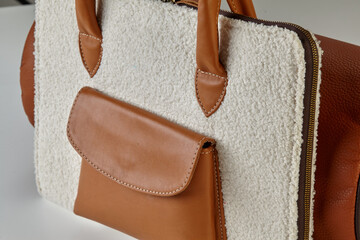 Stylish white and brown leather and shearling tote bag with zipper closure