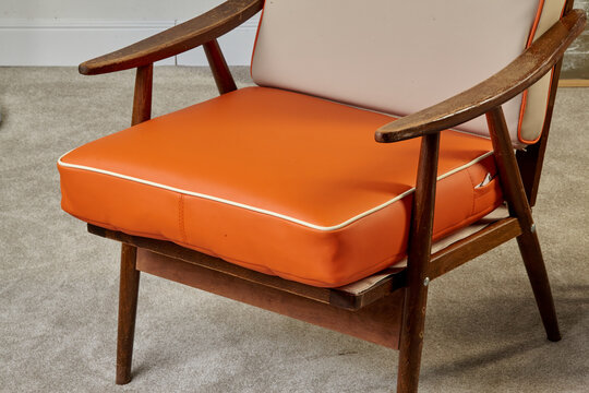 Orange and beige vintage armchair with wooden frame