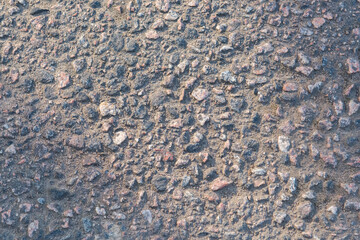 The texture of the asphalt surface, the background is gray asphalt. Rough stone surface of the road.