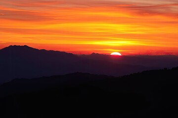 Fiery Sunset Silhouette: Mountains at Golden Hour