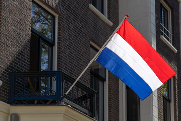 A Dutch flag proudly waves from a building in the Netherlands. For King's Day or Liberation Day 4 May.