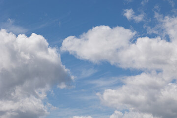 Fototapeta premium White cumulus clouds drifting across a vibrant blue sky