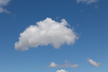 White cumulus clouds drifting across a vibrant blue sky