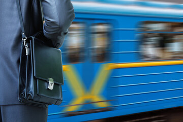 A man with a briefcase waits for the train to arrive.