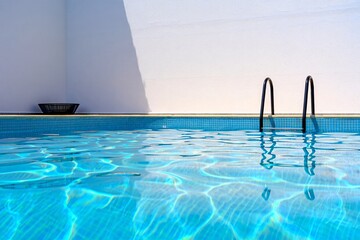 Obraz premium Pool of Tranquility: Sparkling turquoise water shimmers in the sunlight of a modern minimalist pool, offering a refreshing escape and a sense of calm. 