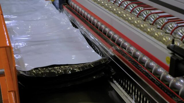 Automated plastic mailing bag production at factory, plant - finished packages are being stacked and prepared for logistics and shipping - close up view
