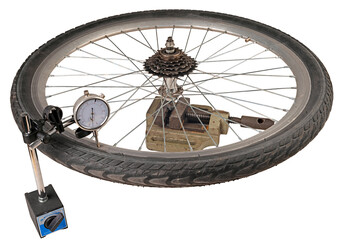 Checking a bicycle wheel with a dial gauge. Isolated background.