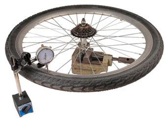 Checking a bicycle wheel with a dial gauge. Isolated background.