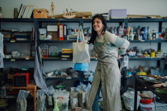 Ceramist feeling back pain while working in her pottery workshop