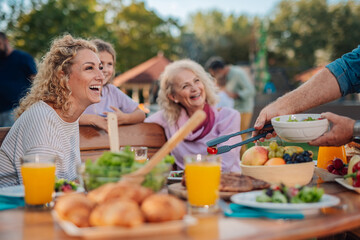 Happy family enjoying backyard barbecue party with delicious food