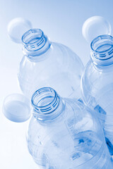 Plastic bottles with so-called tethered caps in monochrome blue. The caps are attached to the drink bottle to prevent it from ending up in nature. The EU bans loose closures and caps on bottles.	