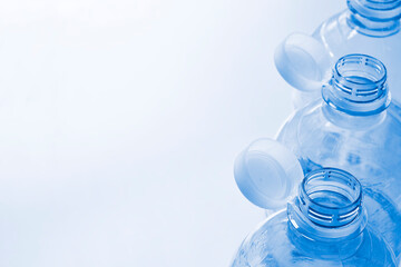 Plastic bottles with so-called tethered caps in monochrome blue. The caps are attached to the drink bottle to prevent it from ending up in nature. The EU bans loose closures and caps on bottles.	