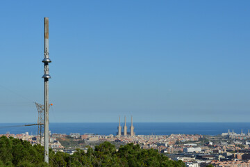 Street lamp in Barcelona, with thermal power station "Tres xemeneies" of Sant Adri&agrave; de Bes&ograve;s in the background. Skyline with electric connection in focus.