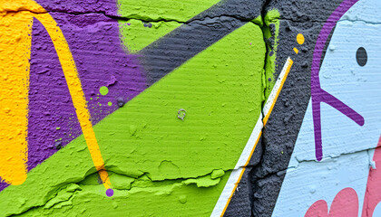 Fragment of old plaster wall with graffiti painting. Part of colorful street art graffiti on wall background. Youth, urban culture. Yellow, green, purple, light blue colors, vibrant. with white shad