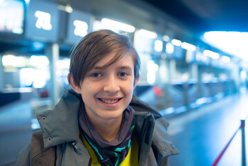 portrait of 12 year old boy in grey jacket at airport	