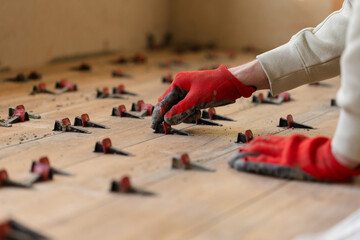 Man Installing Tile Leveling System Components on The Tiled Floor.