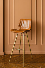 Leather brown chair with high legs in the interior