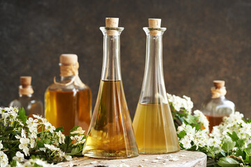 Two bottles of herbal tincture with fresh hawthorn flowers in spring
