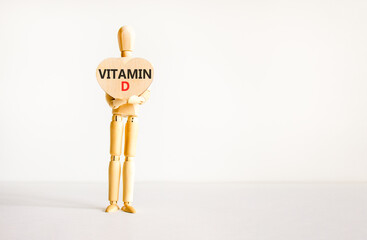 Vitamin D symbol. Concept words Vitamin D on beautiful wooden heart. Doctor's model. Beautiful white background. Copy space. Medical healthy lifestyle Vitamin D concept.