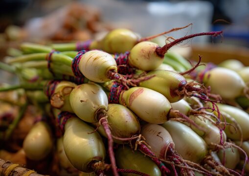 Close-up of fresh fingerroot bundles at a market stall.